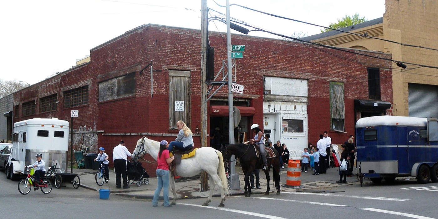 Riders on horseback outside the stable on Caton Place